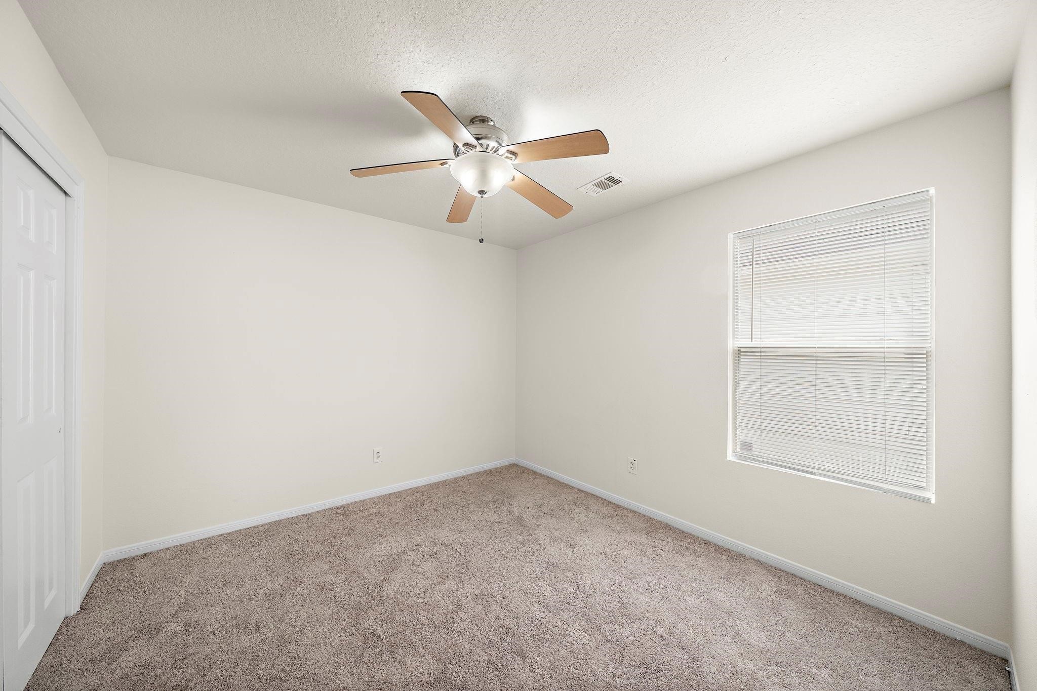 3235 Clipper Winds Way Houston, TX 77084 - Photo 8 of 26 an empty room with a window and a fan