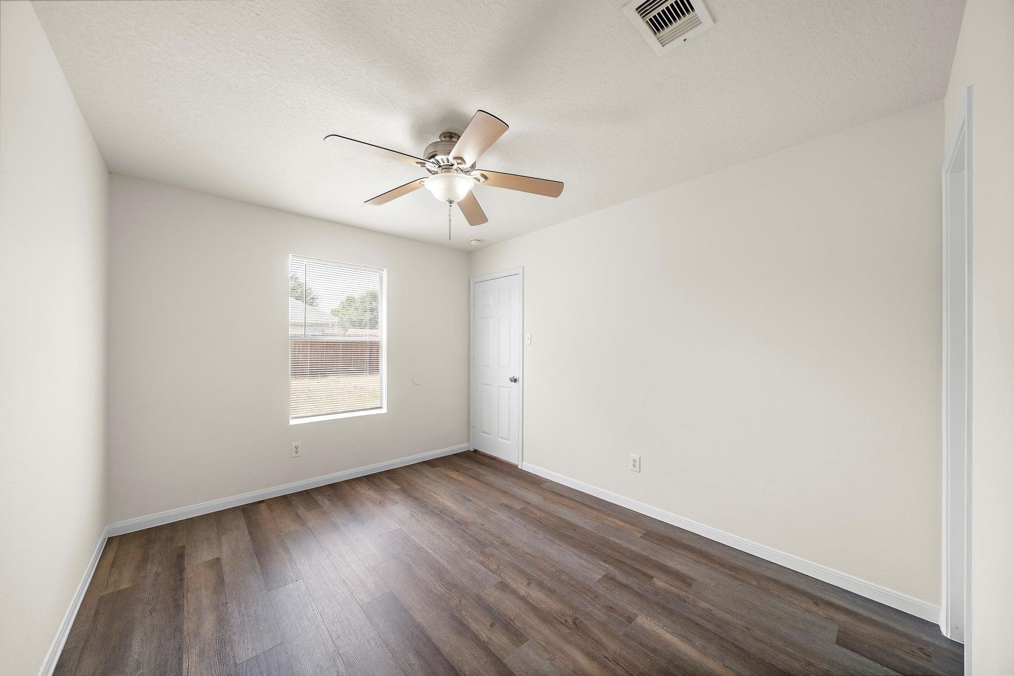 3235 Clipper Winds Way Houston, TX 77084 - Photo 10 of 26 an empty room with wooden floor fan and windows