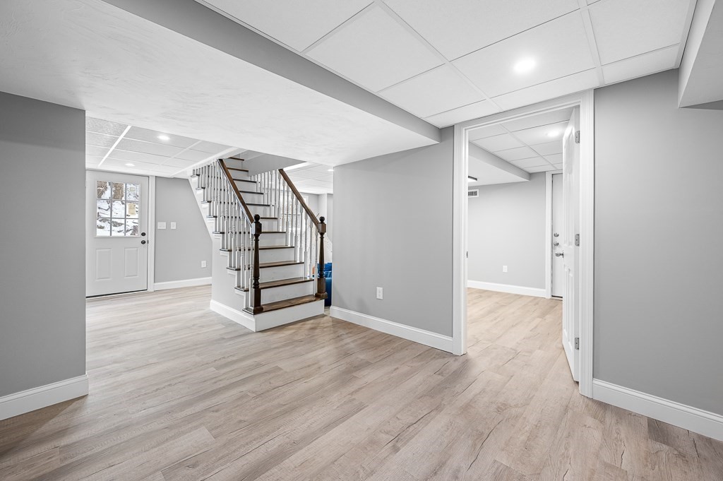137 Fairview Park Road Sturbridge, MA 01566 - Photo 17 of 31 an empty room with wooden floor staircase and windows