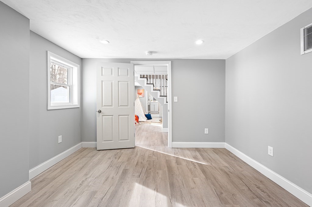 137 Fairview Park Road Sturbridge, MA 01566 - Photo 19 of 31 an empty room with wooden floor and windows