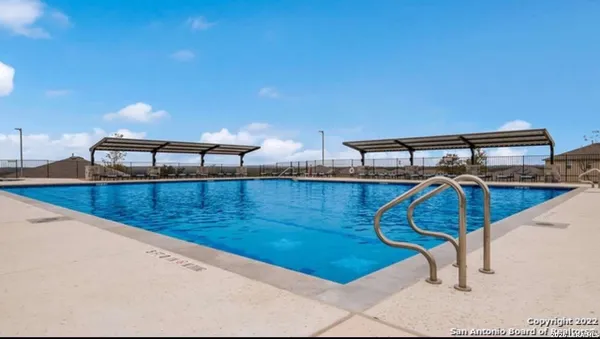 a view of a patio with a table and chairs under an umbrella