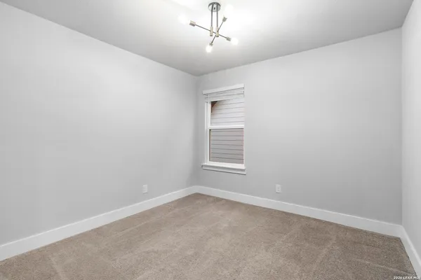 an empty room with a window and a ceiling fan