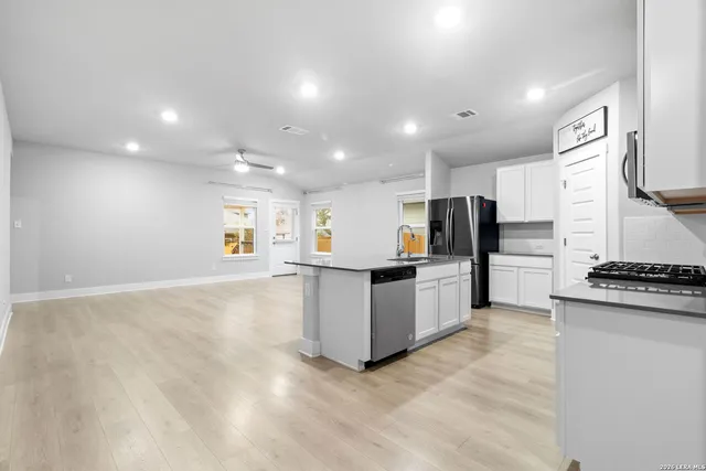 a kitchen with stainless steel appliances a refrigerator sink and stove
