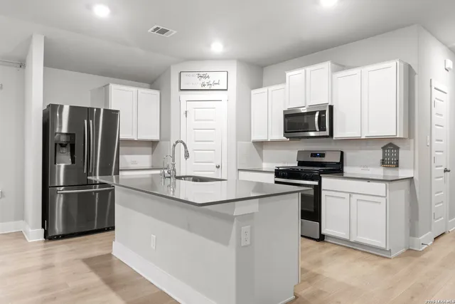 a kitchen with stainless steel appliances granite countertop a refrigerator stove microwave and sink