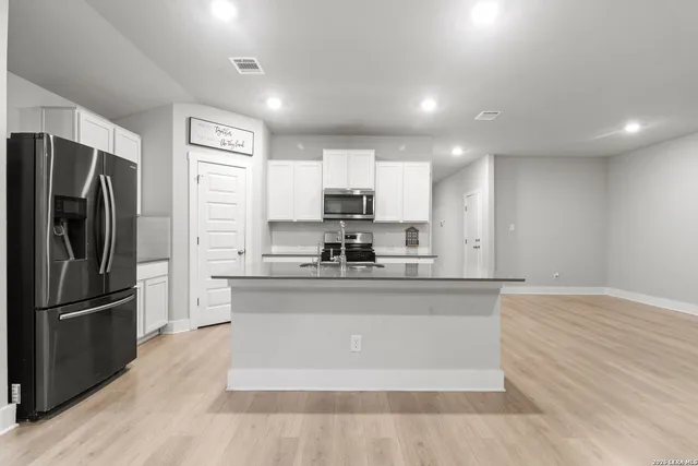 a large kitchen with stainless steel appliances granite countertop a refrigerator and a stove