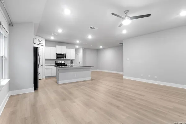 a view of kitchen with kitchen island a refrigerator and a stove top oven