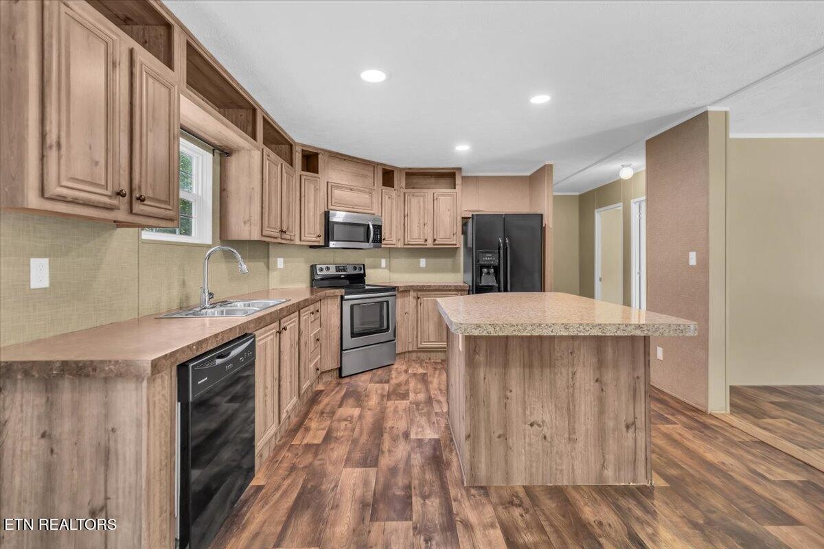 109 Post Oak Springs Road Rockwood, TN 37854 - Photo 12 of 24 a kitchen with kitchen island granite countertop wooden floors wooden cabinets a sink and appliances