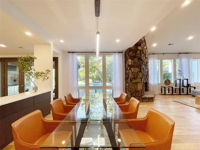 a living room with furniture a large window and dining table