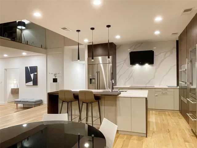 a large kitchen with kitchen island a sink stainless steel appliances and cabinets