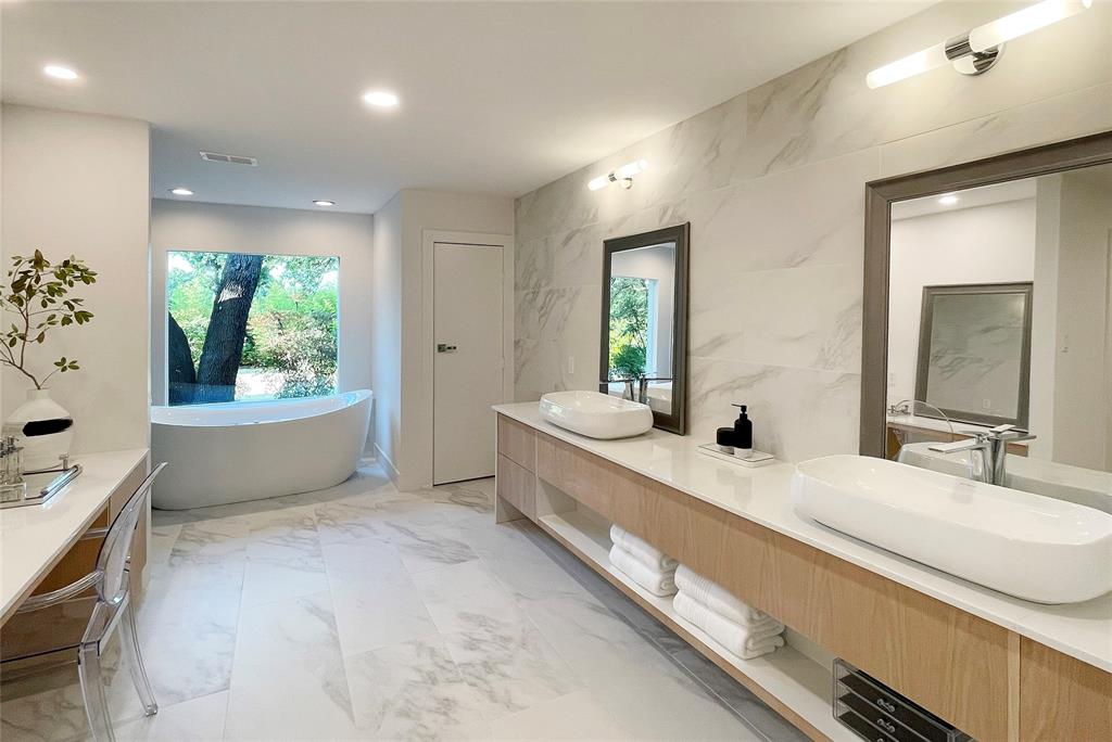6802 Bert Lane Dallas, TX 75240 - Photo 32 of 38 a bathroom with a granite countertop double vanity sink a mirror and a bathtub