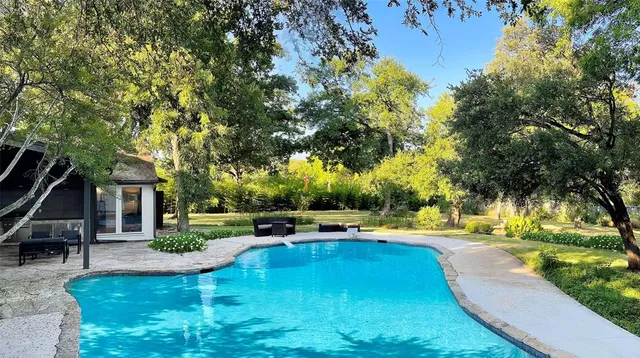 a view of swimming pool with a patio and garden
