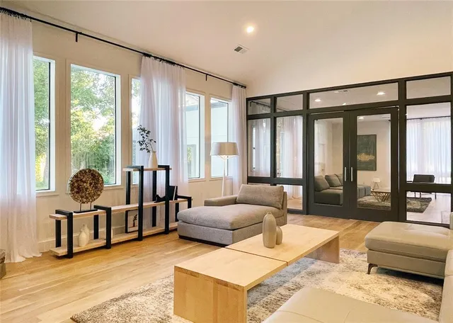 a living room with furniture and large windows