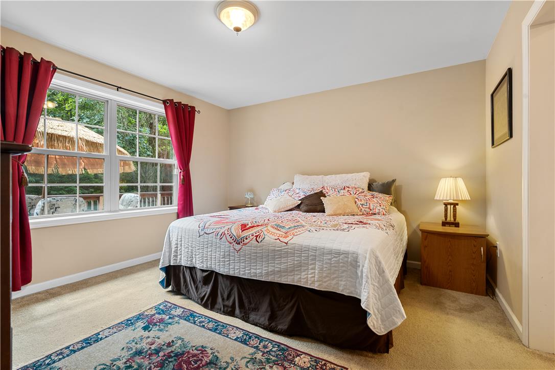 7353 Farrier Road Orefield, PA 18069 - Photo 36 of 74 A spacious bedroom features neutral walls, wall-to-wall carpeting, and large windows overlooking the greenery.