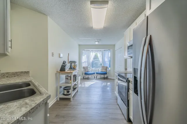 a kitchen with sink refrigerator and cabinets