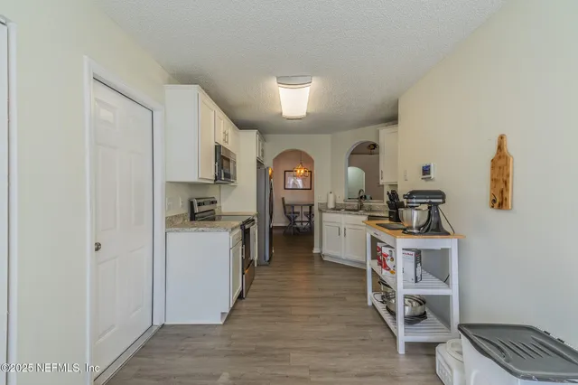 a view of a kitchen with a sink cabinets and wooden floor
