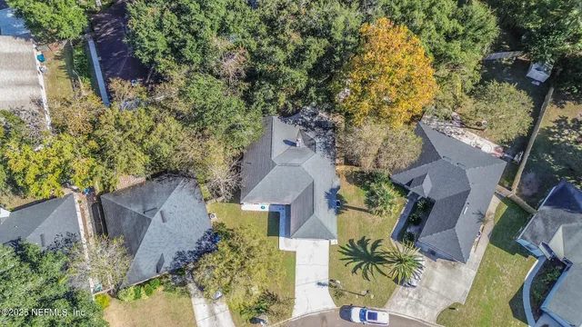 an aerial view of a house with swimming pool and wooden fence