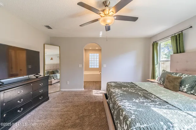 a bedroom with a large bed and a chandelier