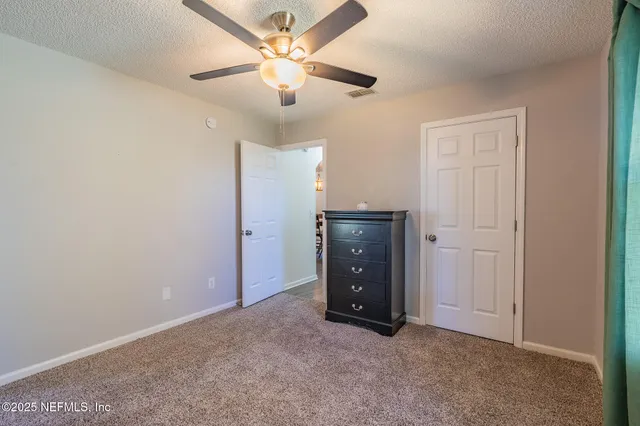 an empty room with chandelier fan