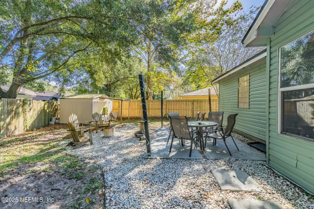 a view of a backyard with table and chairs and a fire pit