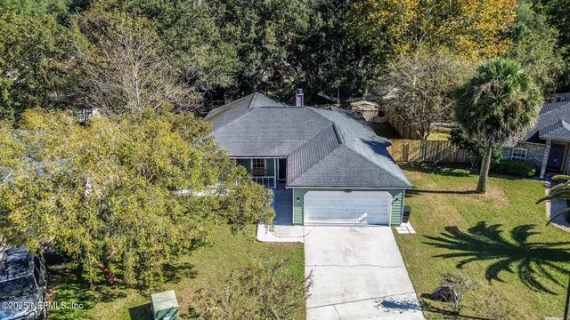 a aerial view of a house with large trees and plants
