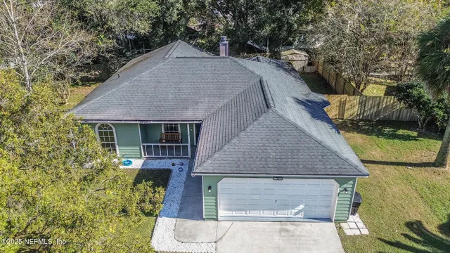 a aerial view of a house next to a yard