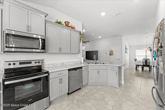 a kitchen with stainless steel appliances a stove microwave and sink