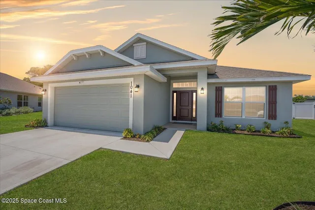 a front view of a house with a garden and yard