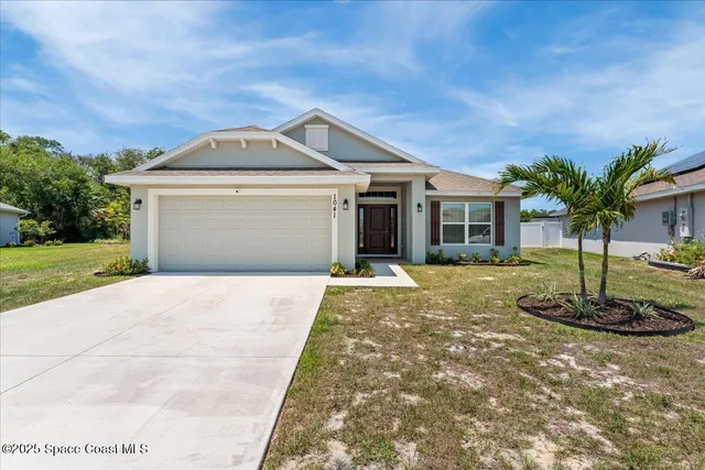 a front view of a house with a yard and garage