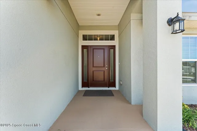 a view of a hallway with wooden floor and a bathroom
