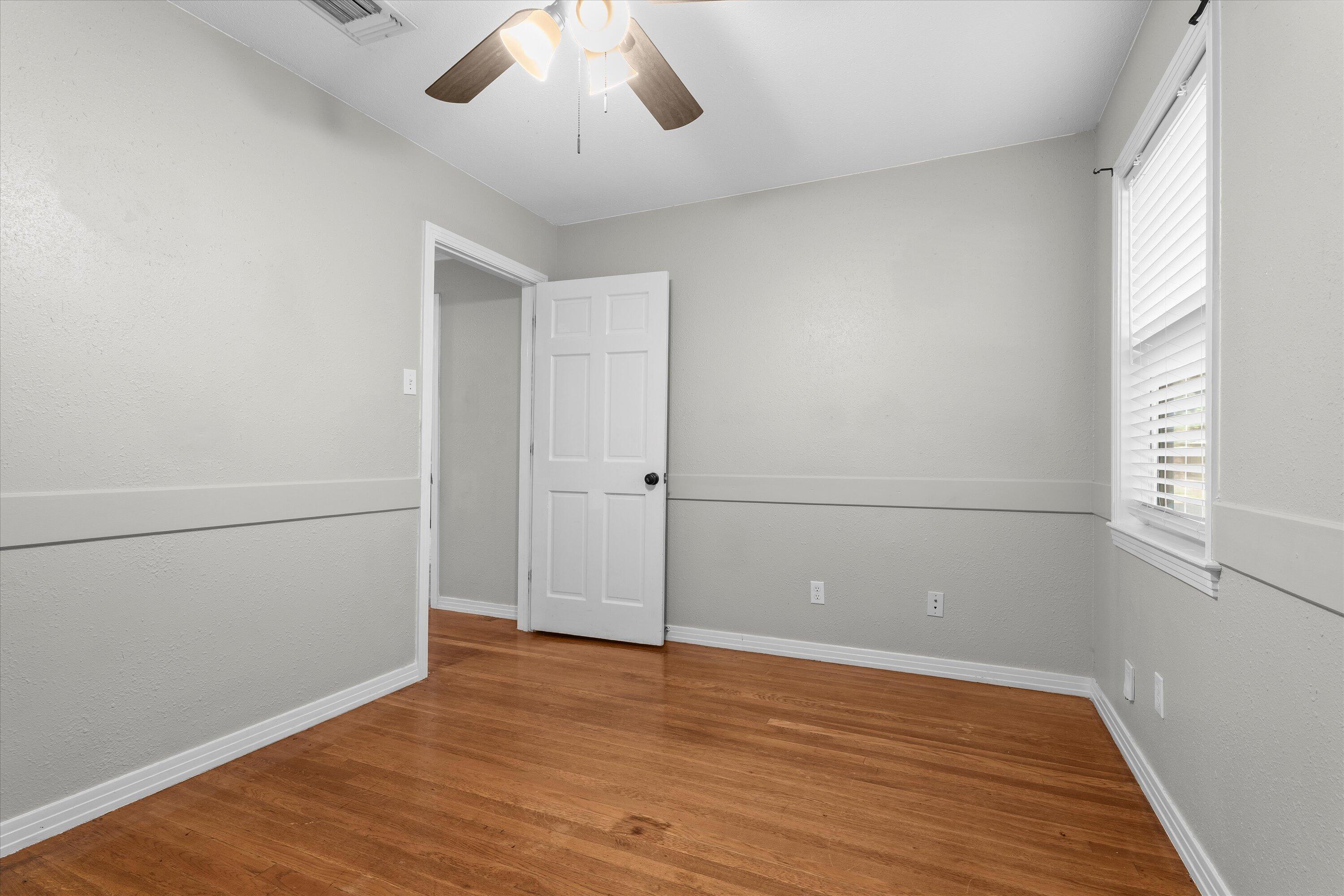 2009 65th Street Lubbock, TX 79412 - Photo 12 of 24 an empty room with wooden floor and windows
