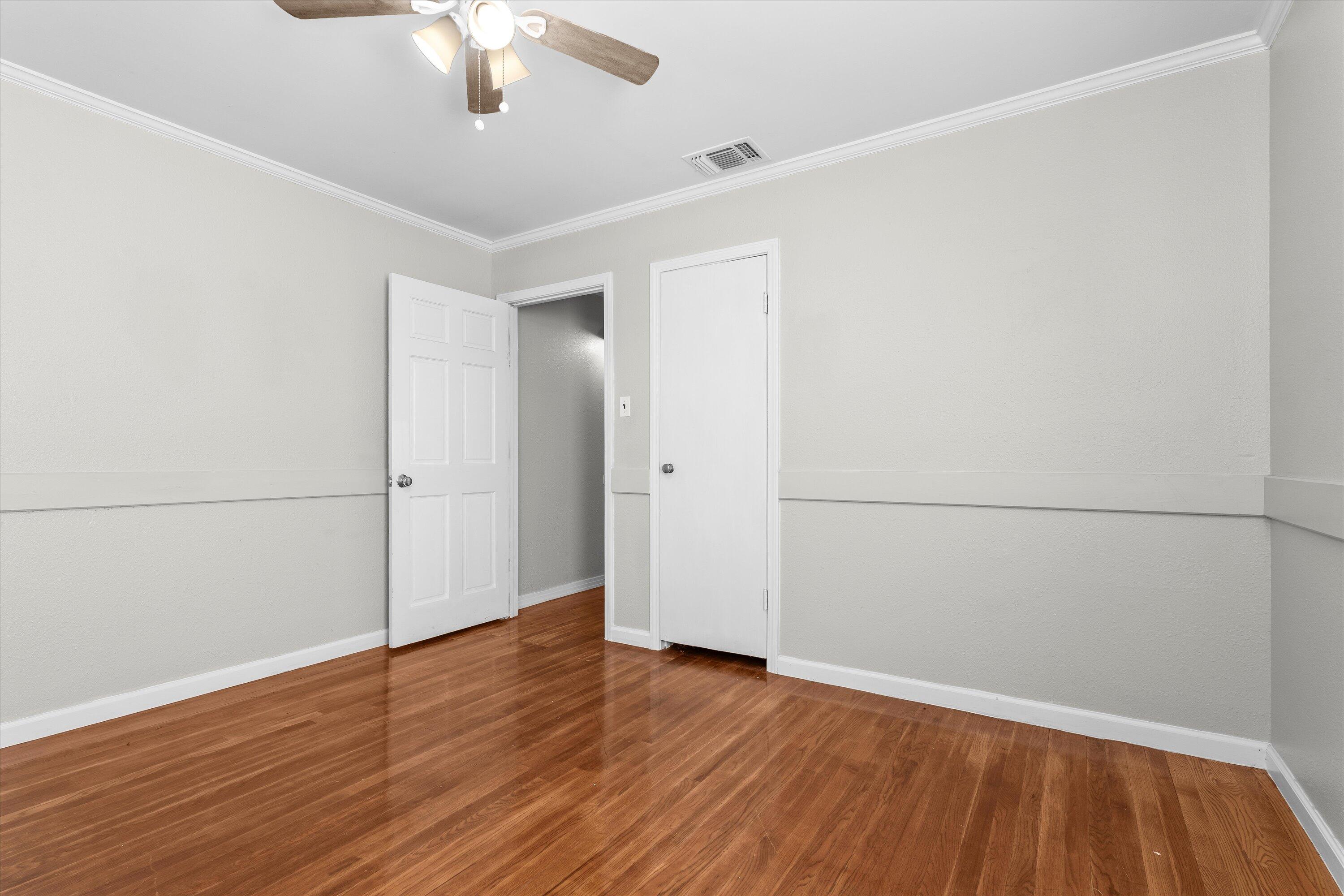 2009 65th Street Lubbock, TX 79412 - Photo 14 of 24 an empty room with wooden floor fan and windows