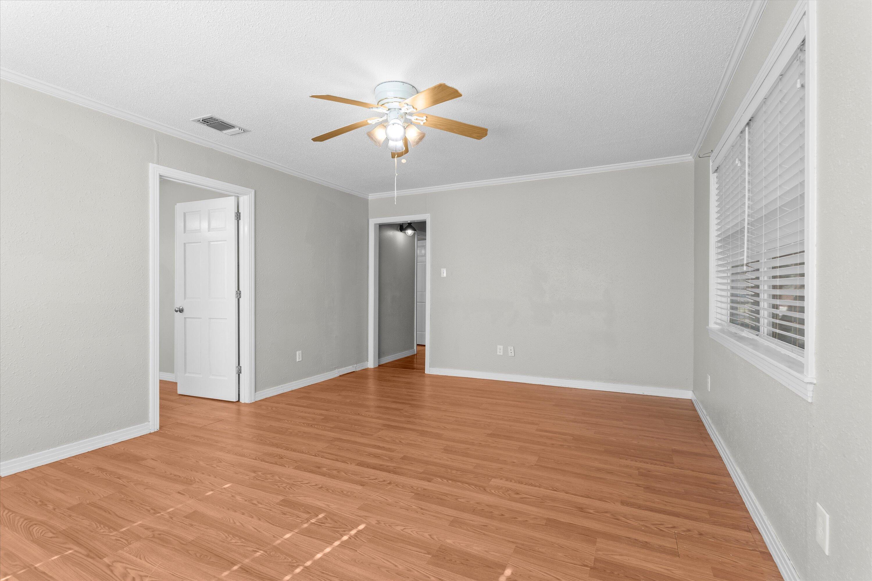 2009 65th Street Lubbock, TX 79412 - Photo 19 of 24 a view of an empty room with wooden floor and a window