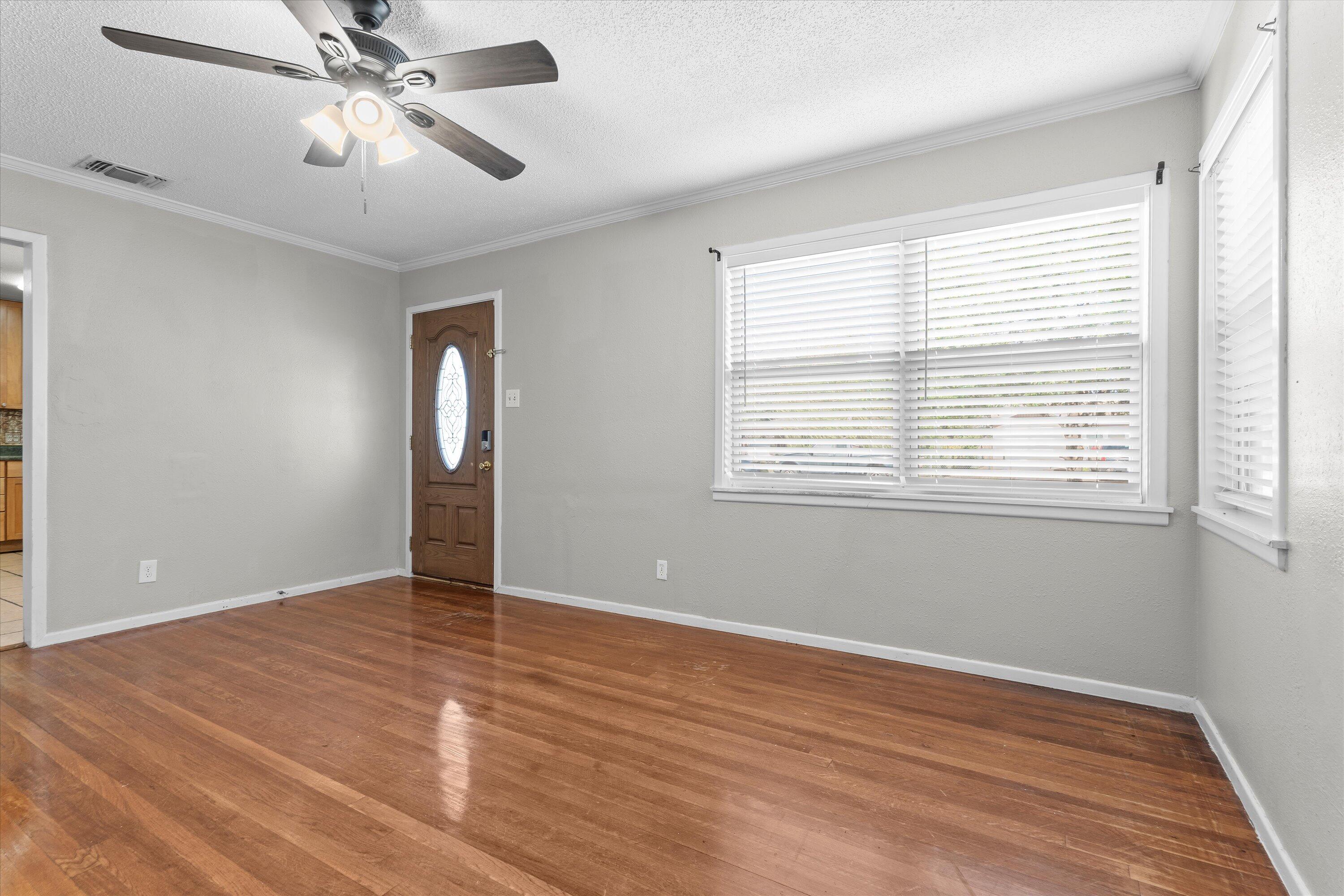 2009 65th Street Lubbock, TX 79412 - Photo 4 of 24 a view of an empty room with wooden floor and a window
