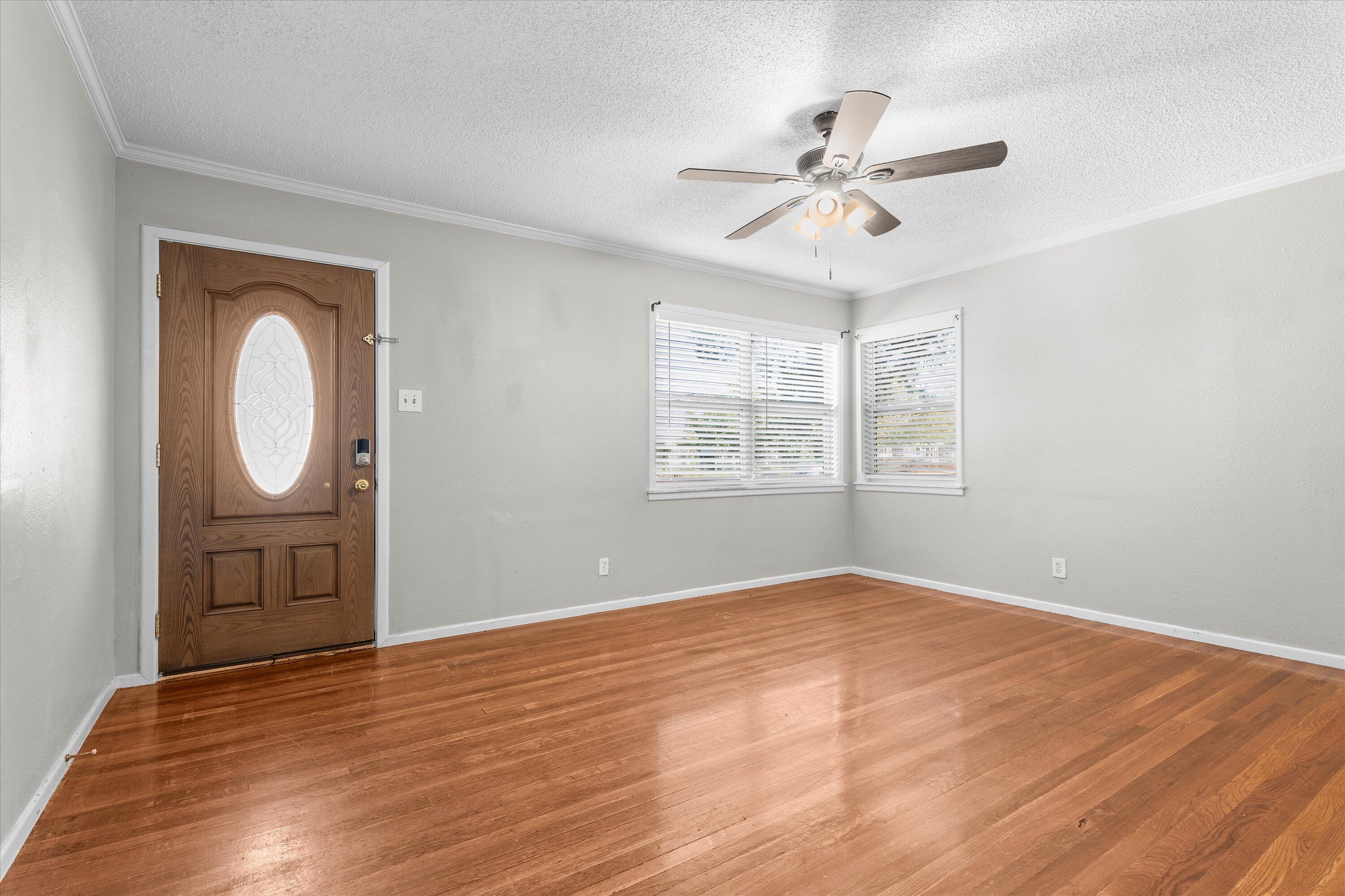 2009 65th Street Lubbock, TX 79412 - Photo 6 of 24 an empty room with wooden floor fan and windows