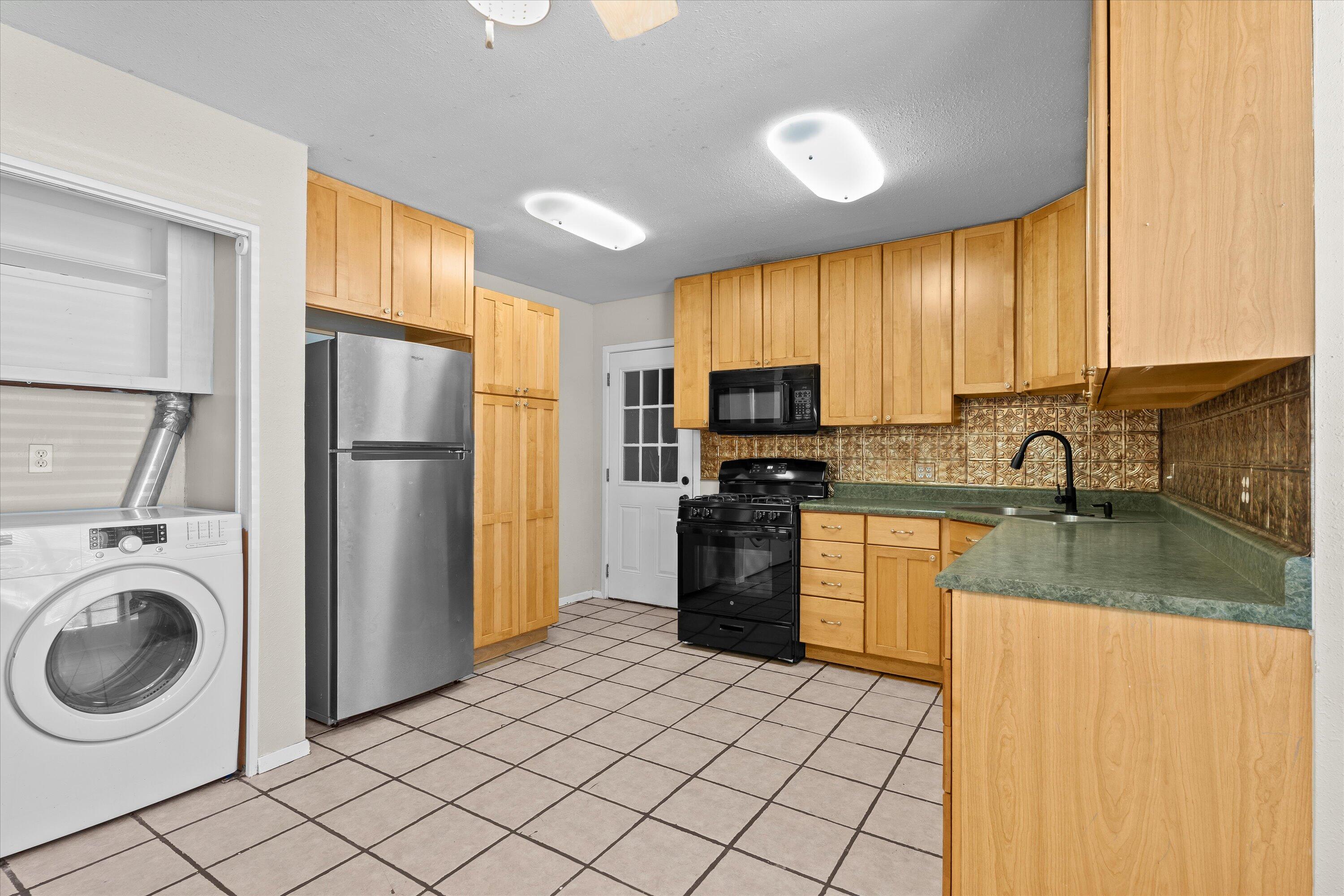 2009 65th Street Lubbock, TX 79412 - Photo 8 of 24 a kitchen with a refrigerator a stove top oven a sink and dishwasher