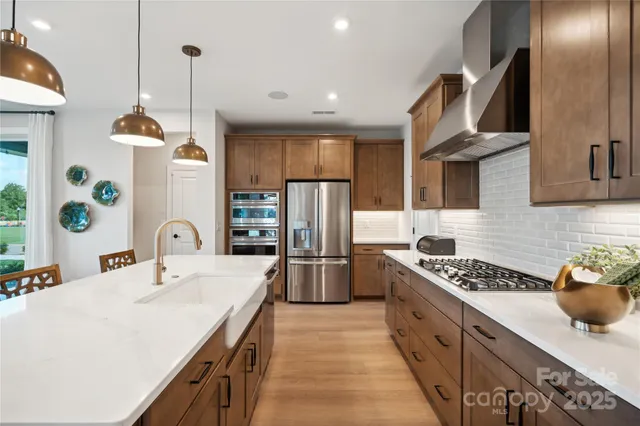 a kitchen with stainless steel appliances a sink stove and refrigerator