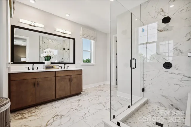 a bathroom with a double vanity sink mirror and shower