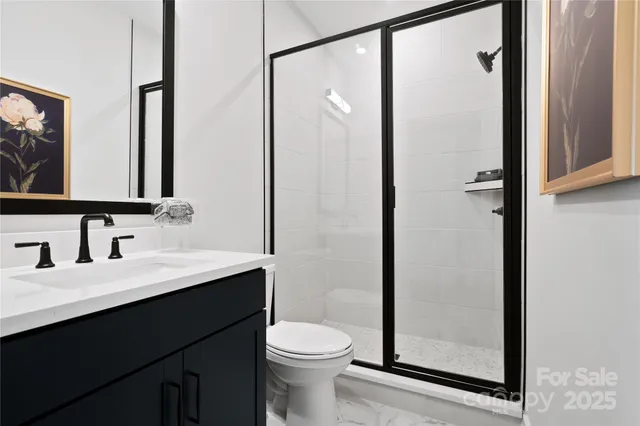 a bathroom with a sink a toilet a mirror and shower