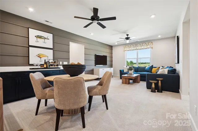 a living room with furniture kitchen view and a large window