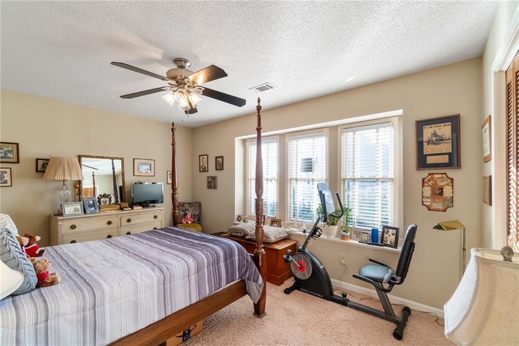 3492 Rosebud Road Loganville, GA 30052 - Photo 15 of 22 a bedroom with a bed and a chandelier