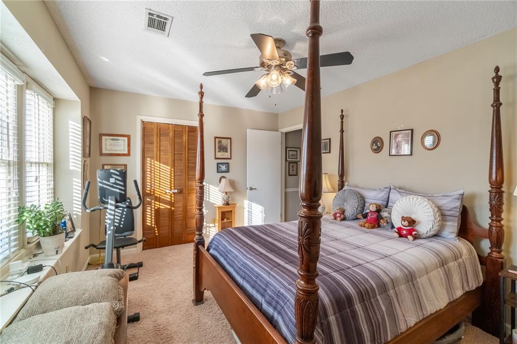 3492 Rosebud Road Loganville, GA 30052 - Photo 16 of 22 a bedroom with a bed and a chandelier