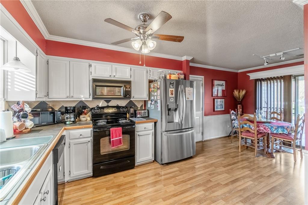 3492 Rosebud Road Loganville, GA 30052 - Photo 9 of 22 a kitchen with stainless steel appliances granite countertop a refrigerator stove top oven and sink