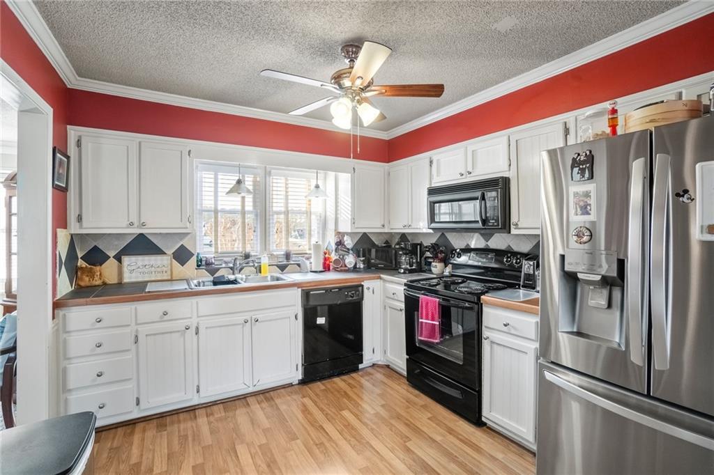 3492 Rosebud Road Loganville, GA 30052 - Photo 10 of 22 a kitchen with stainless steel appliances a refrigerator sink and cabinets