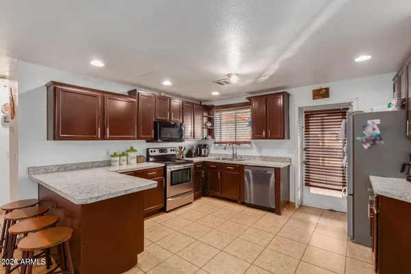 a kitchen with stainless steel appliances granite countertop a stove top oven a sink dishwasher and a refrigerator