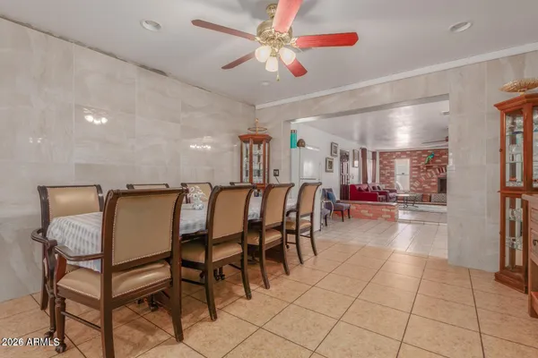 a dining hall with a dining table chairs and white cabinets