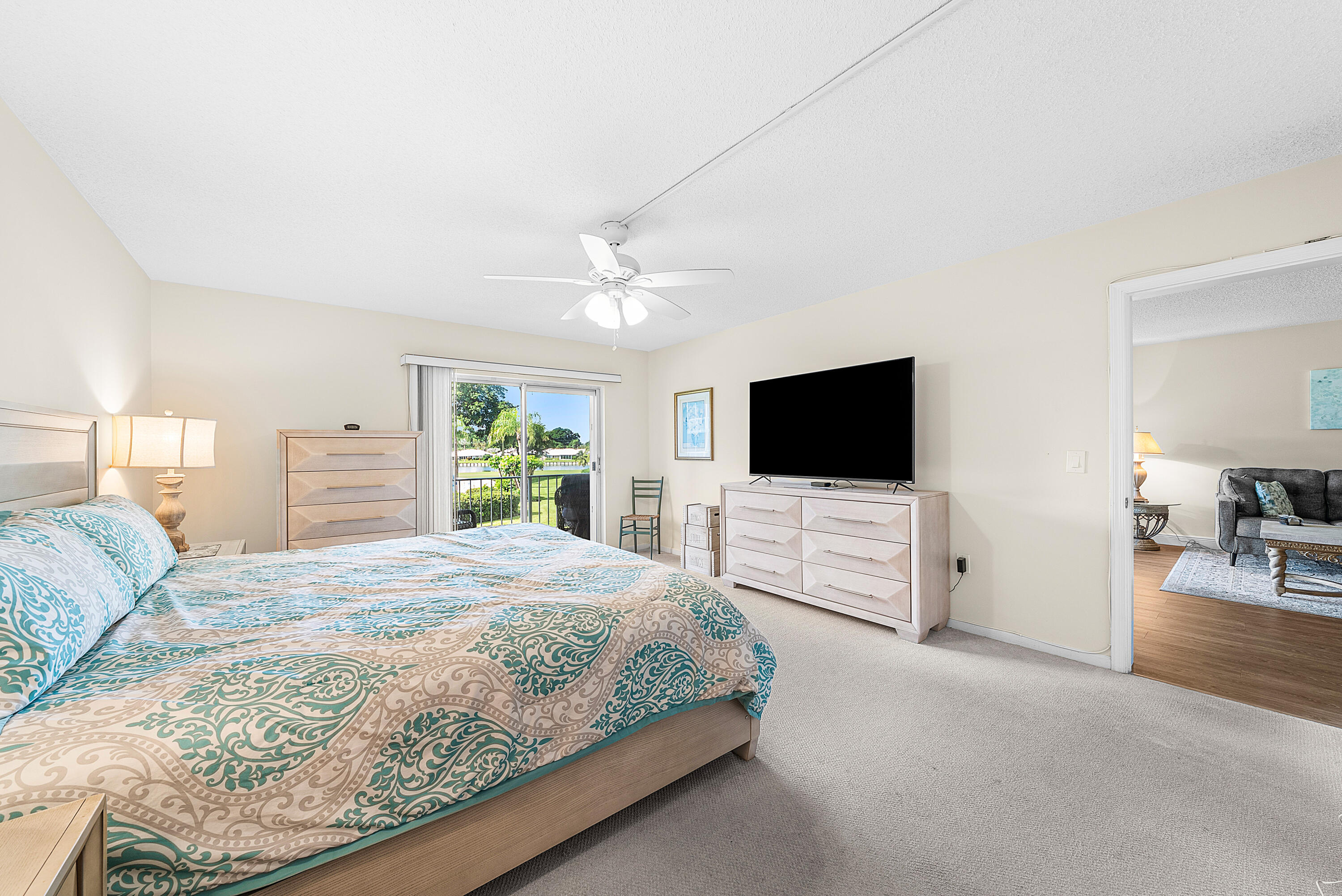 145 Atlantis Boulevard, Unit 203 Atlantis, FL 33462 - Photo 14 of 33 a bedroom with a large bed and a flat screen tv