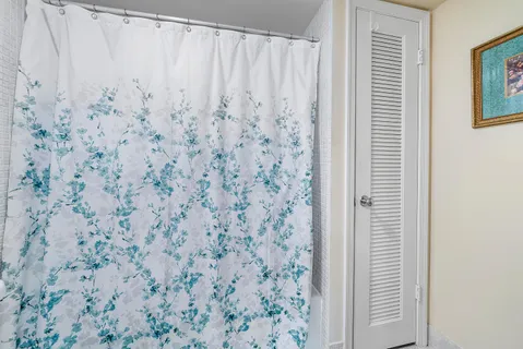 a bathroom with a shower curtain and a window