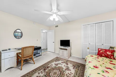 a bedroom with a bed and a chair with the bookshelf