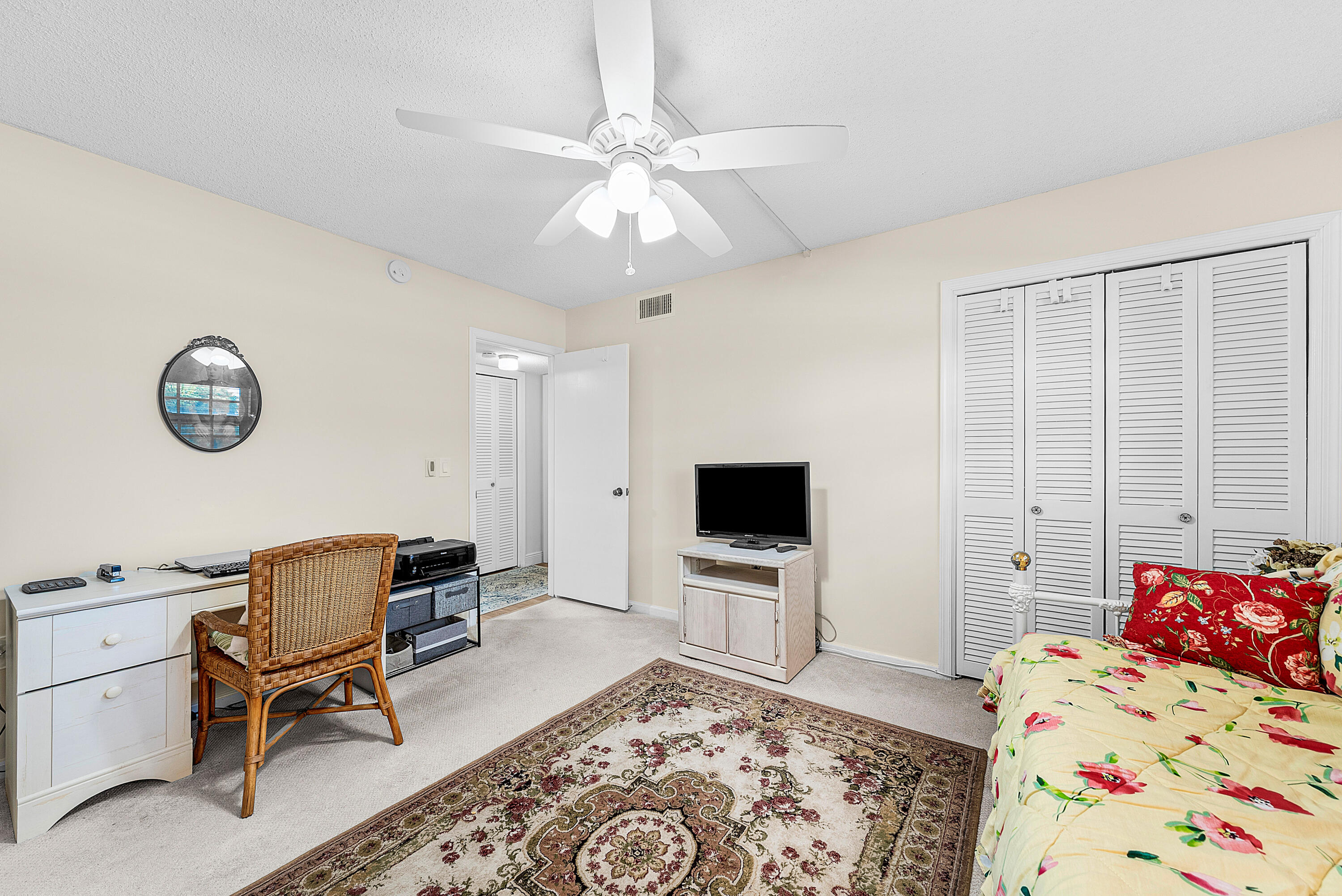 145 Atlantis Boulevard, Unit 203 Atlantis, FL 33462 - Photo 18 of 33 a bedroom with a bed and a chair with the bookshelf