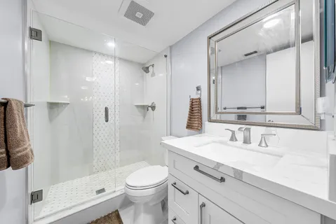 a bathroom with a sink a toilet and shower